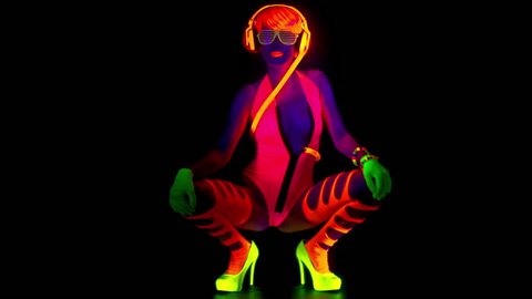 sexy female disco gogo dancer poses in UV costume and makeup 

