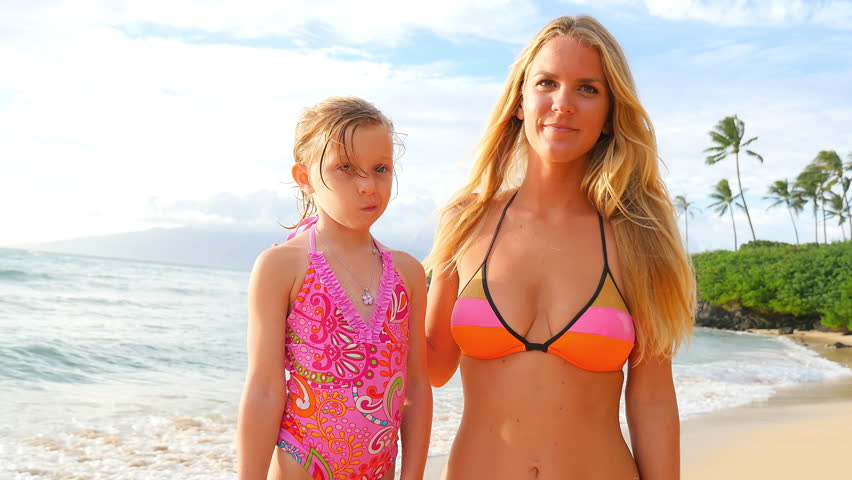 Blonde mother and daughters smiling on a beach Shutterstock HD Video #83181...