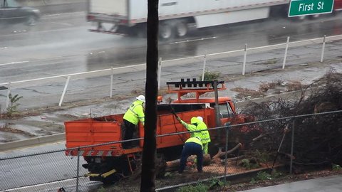 BURBANK CA, NOV 2014 - Roadside crew clearing debris from freeway during rainstorm. 
