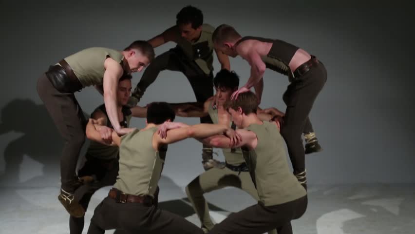 Group of seven young men in costumes do acrobatic pyramid Royalty-Free Stock Footage #8323903