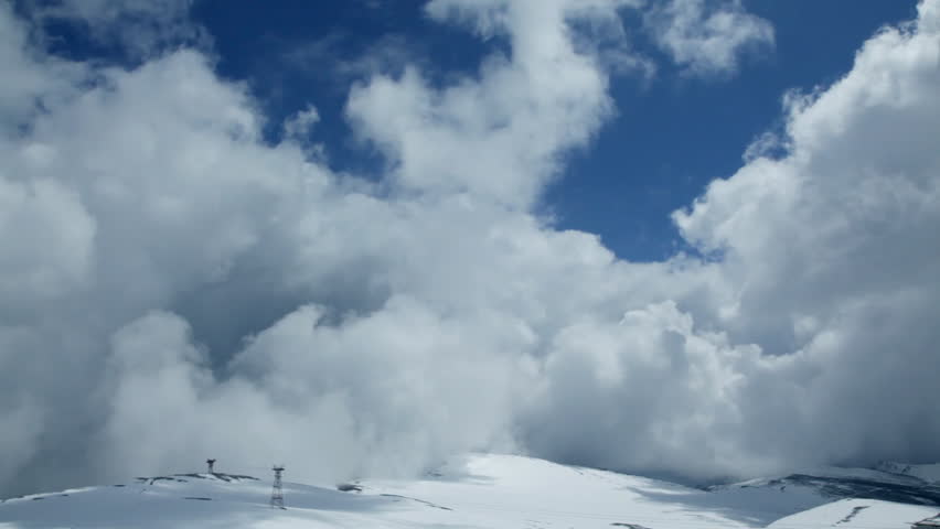 Stormy clouds on top of snowy mountain,time lapse