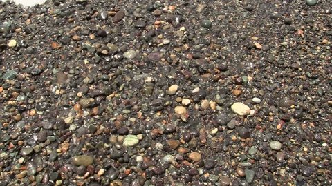 Ocean waves break on pebble beach 