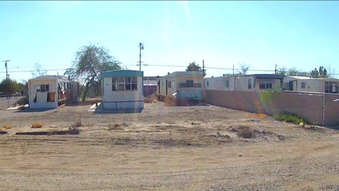 NILAND, CA: December 16, 2014- Shot of driving by mobile homes in a small desert town circa 2014 in Niland. A rural community features neighborhoods filled with trailer park homes.