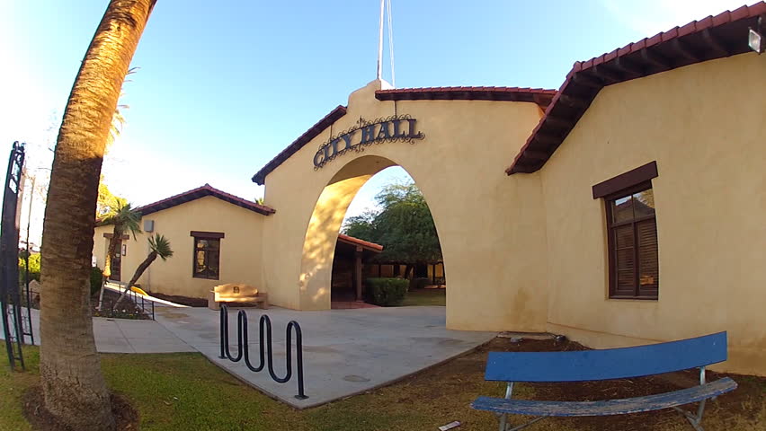 Wide angle shot of a generic, new city hall entrance way in Brawley, California. A large arch grants access and entry under a sign that simply says "City Hall".