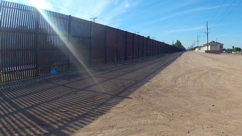 Shot of the border fence in Calexico, California. A lonely stretch of Fence or wall separates Mexico from the United States.