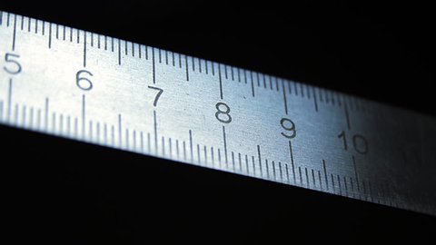 Metal ruler on black background. The movement of metal ruler. Closeup