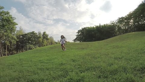 slow motion asian girl running down from small hill