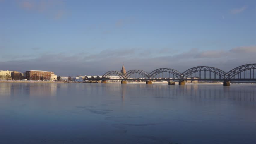 The train goes over the bridge on the background panorama of Riga in the winter