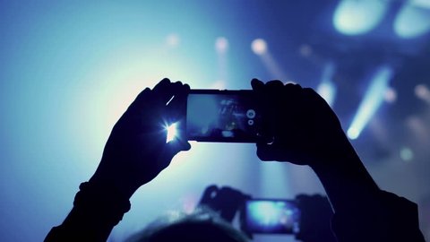 Person records rock concert on cellphone in the club, steadycam shot
