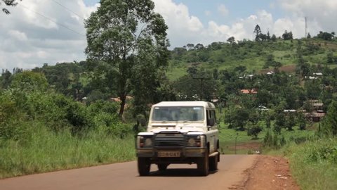JINJA, UGANDA - SEPTEMBER 2013: A Land Rover drives down a rural road in Uganda, Africa