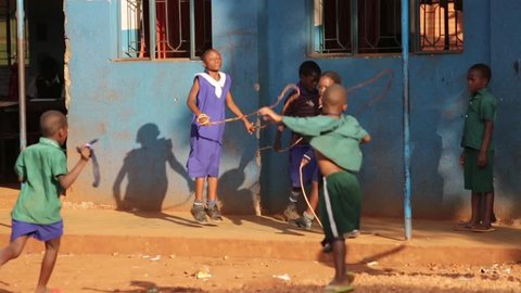 Young happy African children playing skipping at school in rural Uganda
