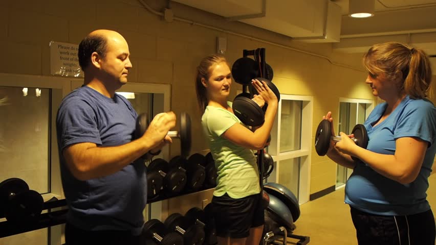 Group using weights to exercise at a gym.