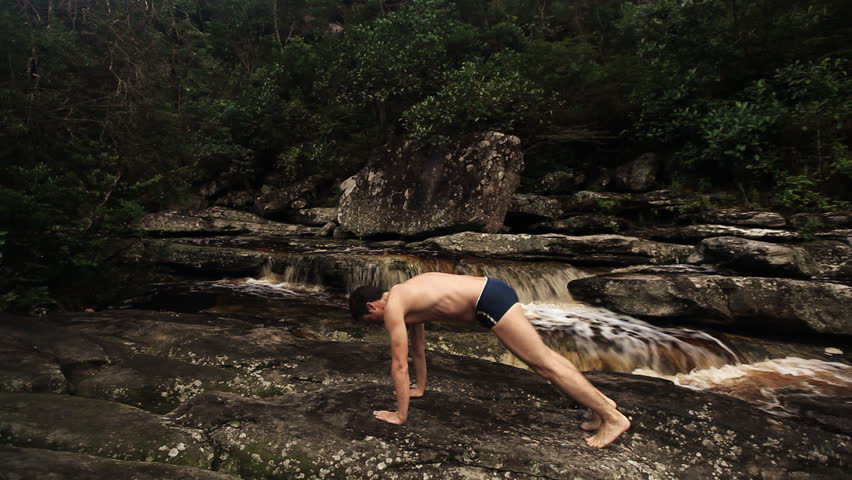 Man practicing yoga exercises surrounded by a beautiful river / HD1080 / 30fps