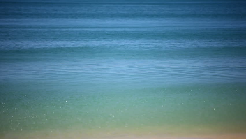 Close up of turquoise water surface of atlantic ocean with gentle surf