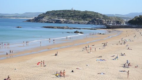 SANTANDER, SPAIN, OCTOBER 30, 2014: People are enjoying last sunny day in november on a beach in spanish coastal town santander.
