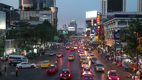 Bangkok, Thailand - December 14 2014: Cars rush at dusk on Ratchadamri road in a prime shopping district near Siam Square in Thailand capital city. Shot as a time lapse video with a panned movement.