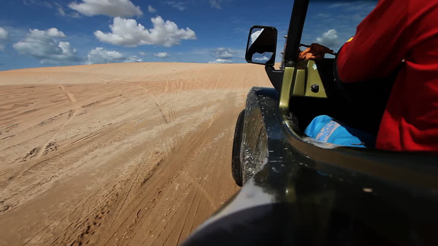 Though ride through sand dunes with a buggy, viewed from vehicle 