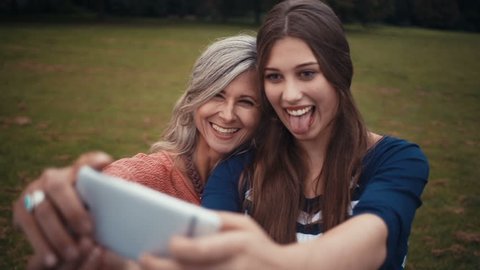 Mother and daughter pose together for a selfie with their smart phone
