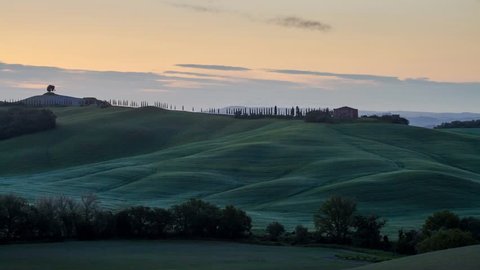 Early morning sun rising over Tuscany hills, Italy, time lapse