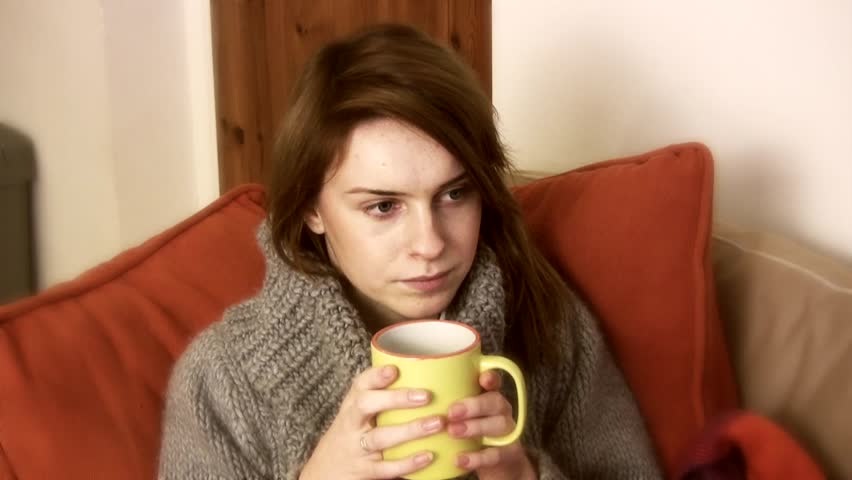 Young woman aged 20 to 25 years, with drinking mug, sitting indoors on sofa watching TV Royalty-Free Stock Footage #8394823