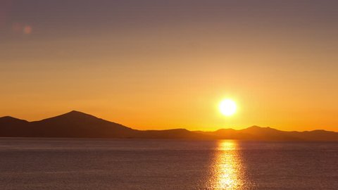 4K scenic sunrise background sun rising.
Wide view timelapse of sun rising behing sea and mountains in Greece.
All unwanted elements been digitally removed,and sequence has been deflickered.