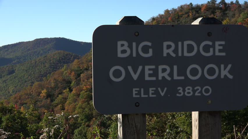 Zoom out from sign of Big Ridge overlook on Blue Ridge Parkway road near Asheville, NC, USA on a sunny day with blue sky.
