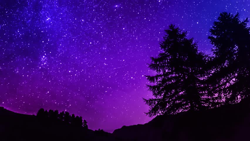 star trails time lapse galaxy night sky over mountain. Blue and purple sky. 4K resolution