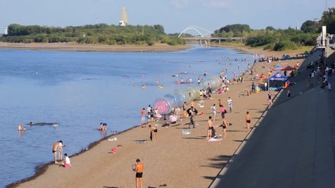 AUGUST 23, 2014 - Heihe Heilongjiang River Beach 03. River Heilongjiang (Amur), beach on the shore, people resting and swimming. Sunny summer day of August 23, 2014. Town of Heihe, China. 