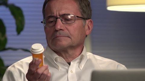 Man looking at prescription at computer - Close