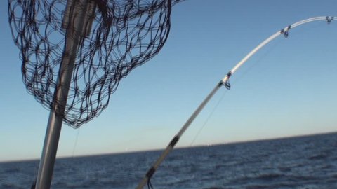 Landing net and fishing rod on the boat while trolling.