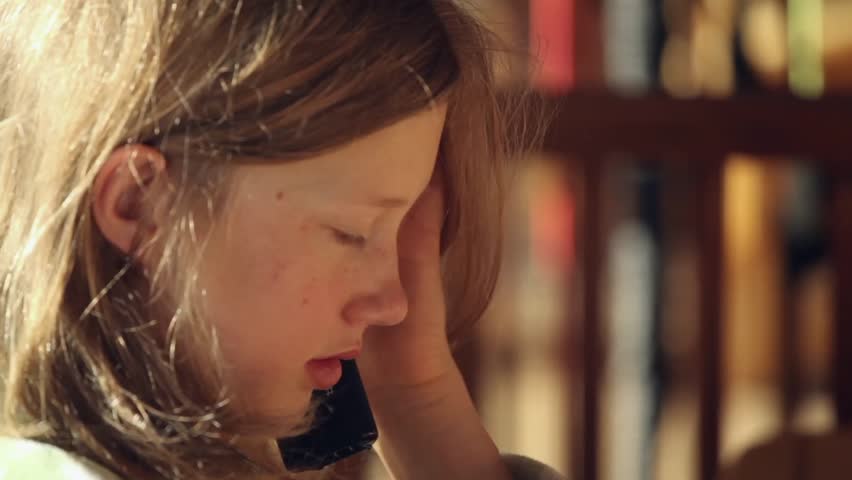 Girl talking on a telephone during breakfast