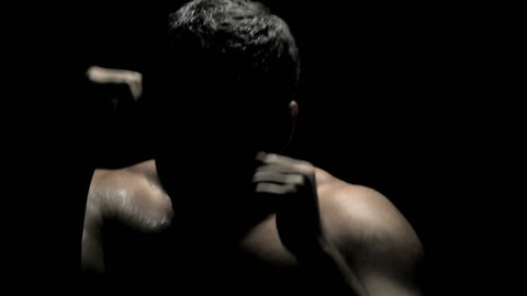 Boxing in the Dark - Caucasian Boxer Spars, Throwing Punches on Black Background