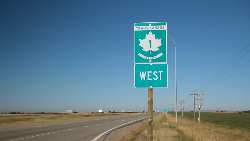 Trans Canada Highway 1 sign in Alberta, Canada. Eighteen wheeler truck passes.