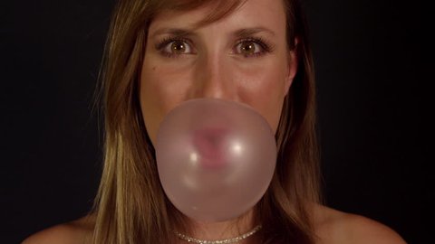 SLOW MOTION: Woman blowing gum bubbles