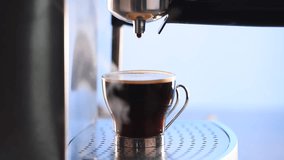 Modern glass cup of black coffee brewing via a metal espresso machine, hd, 1080p high definition.