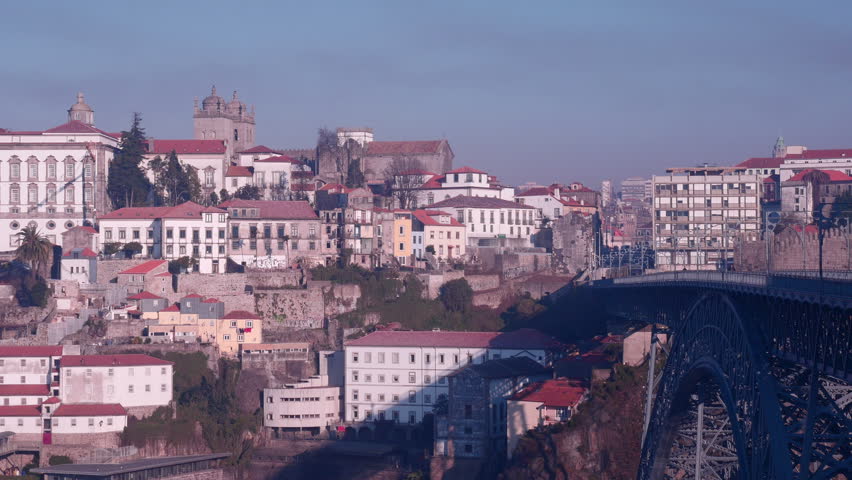 This is a static shot of the skyline of Porto, Portugal with a metro train going through. 