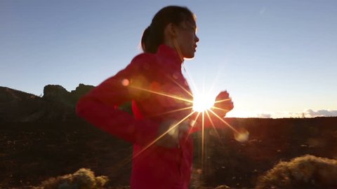Asian woman runner running on mountain road at sunset. Female athlete training and working out for marathon living healthy active lifestyle outdoors in beautiful nature.