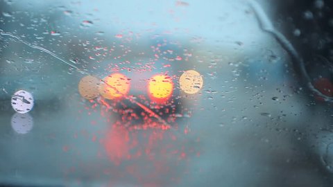 Bad weather, rain and wet snow on the evening dark road. Evening driving, Wet slippery road, rain drops and wet snow on the windshield.  Car headlights.  cars in motion. Traffic in poor visibility