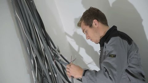 Electrician preparing electric system in house under construction