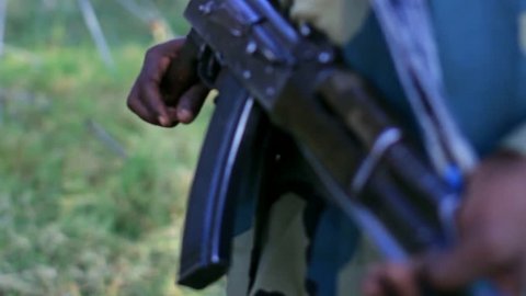 Ethiopian soldier holding AK 47 riffle aka Kalashnikov. Closeup with shallow deep of field shows riffle prepared to use. 