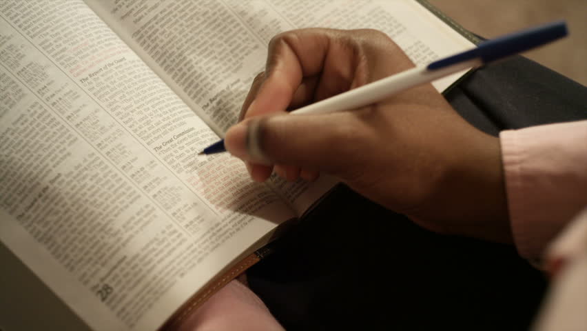 An African American woman performs various tasks around the house. She  reads a book.