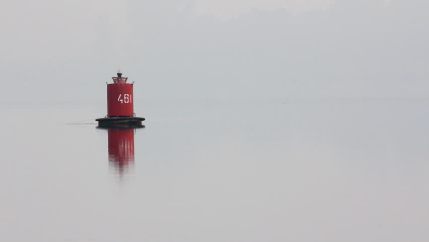 flashing buoy on river in morning mist