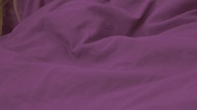 Beautiful blonde girl dreaming in the bed with purple covers 4K 2160p UHD footage - Woman sleeping in purple bed covers 4K 3840X2160 UHD video
