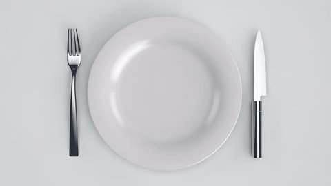 Empty plate. Move a white plate with a knife and fork on a white background.