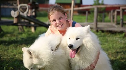cheerful girl and eskimo dogs at summer camp