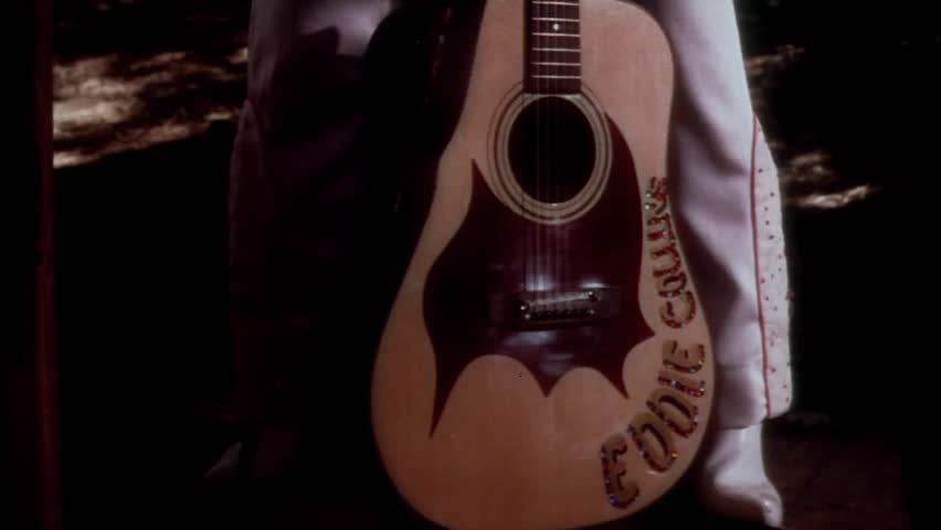 Tilt up shot of Elvis impersonator with guitar