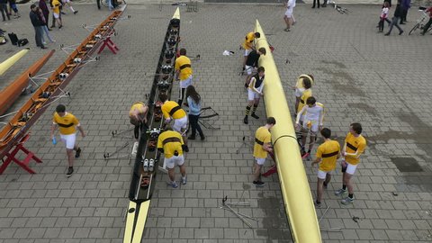 November 21, 2014. Amsterdam, the Netherlands.Two rowing teams work on their boats while a third team walks by carrying their boat over their heads. Wide, overhead shot. Editorial Stock Video