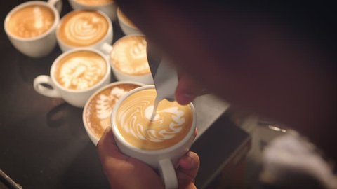 Barista prepares latte in take away cup