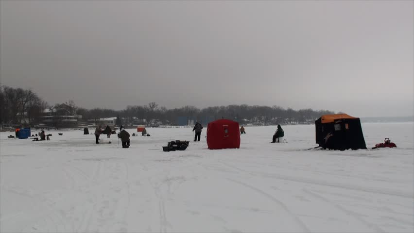 Channel Lake, Illinois 60002 USA 2012-01-22. Group of people ice fishing on frozen lake 2. The film was shot in late January in cloudy day.