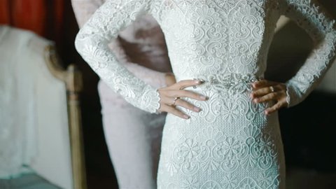 Preparation for the wedding. Bride touches her lace wedding dress with her beautiful manicured fingers 
 Stock Video